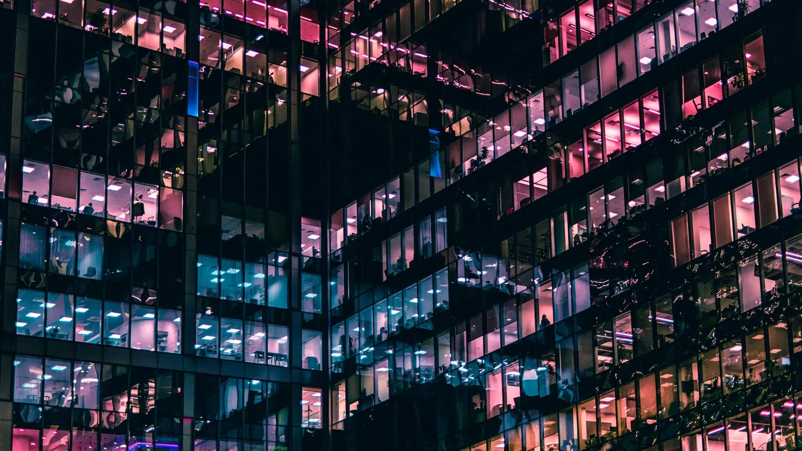 Office tower at night with lit windows on many floors, representing companies assessing their AI readiness