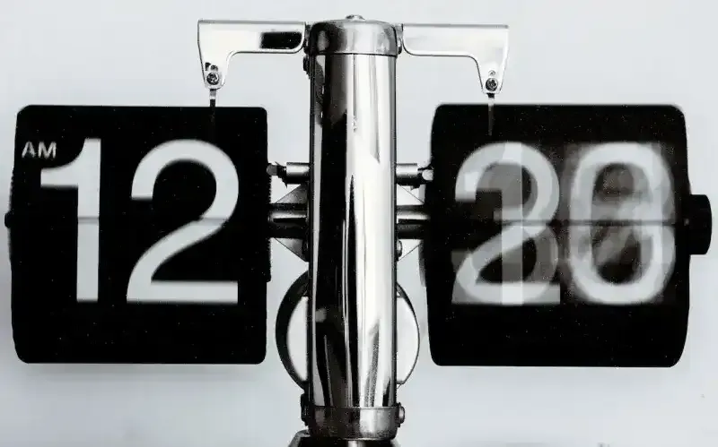 Black and white flip clock turning from 12:20 to 12:30, suggesting speed in moving from design to code.