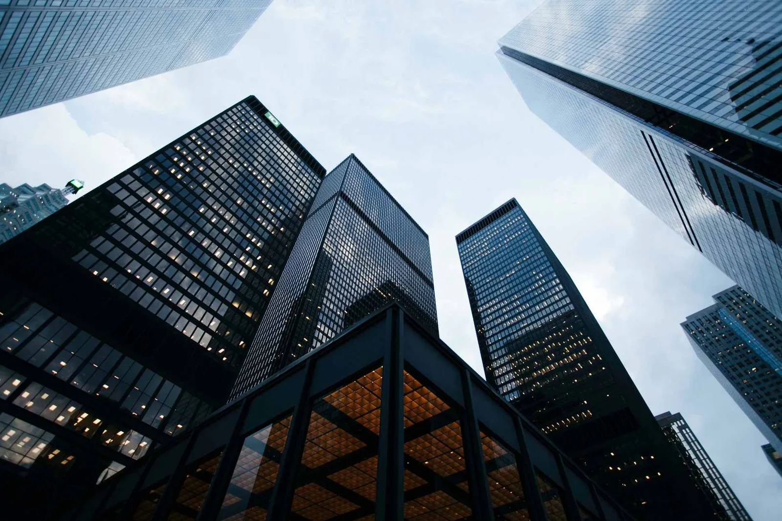 Low-angle view of glass office towers against a cloudy sky, used for the Consero finance-as-a-service customer story.